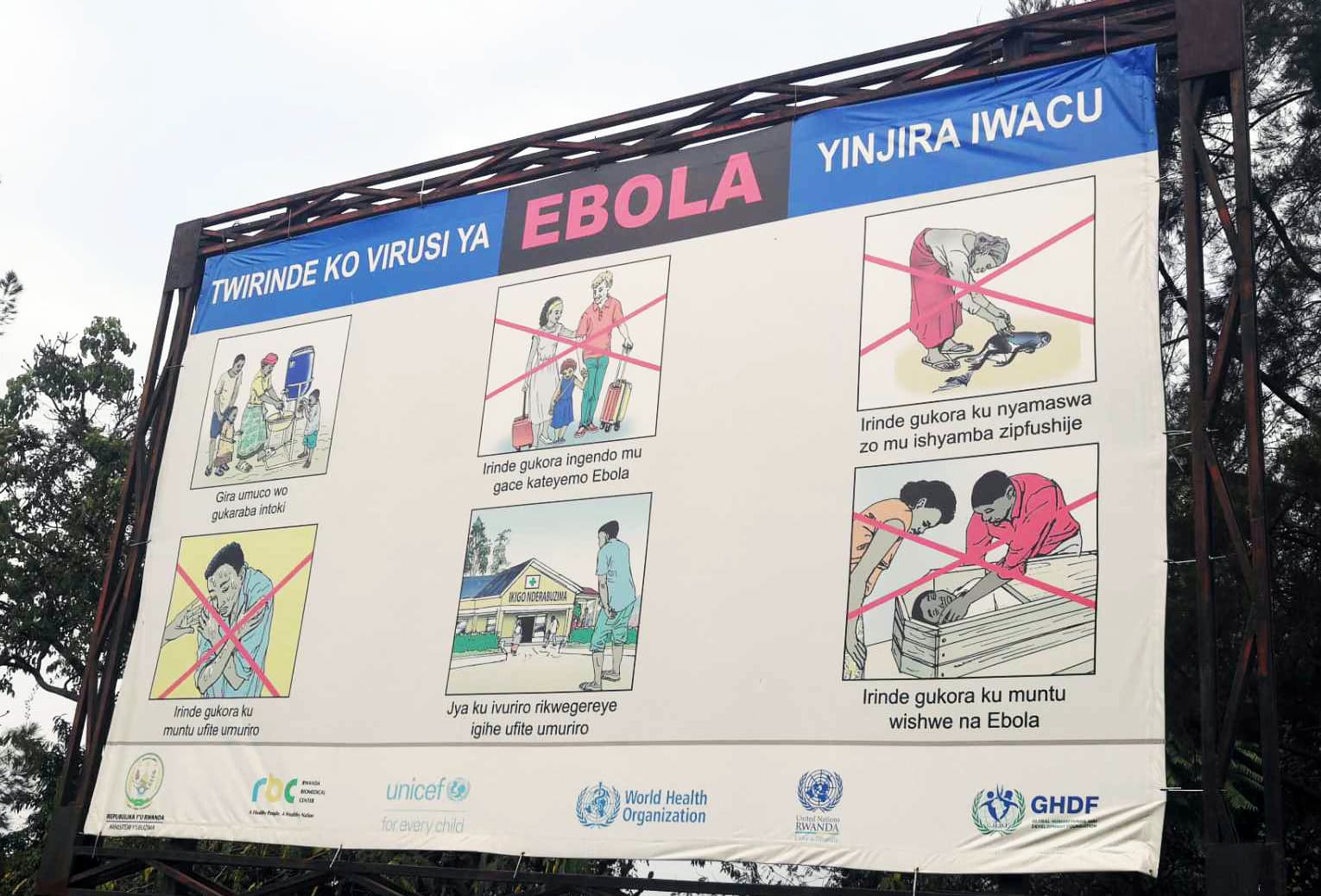 Ebolan torjumiseen ohjeistava suuri, kuvitettu kyltti Goman ja Gisenyin rajalla.