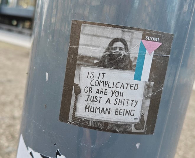 A pole with a sticker that says is it complicated or are you just a shitty human being.