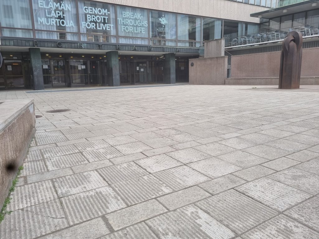 Porthania building's courtyard empty. There's gray concrete and the wall of Porthania building in the photo.