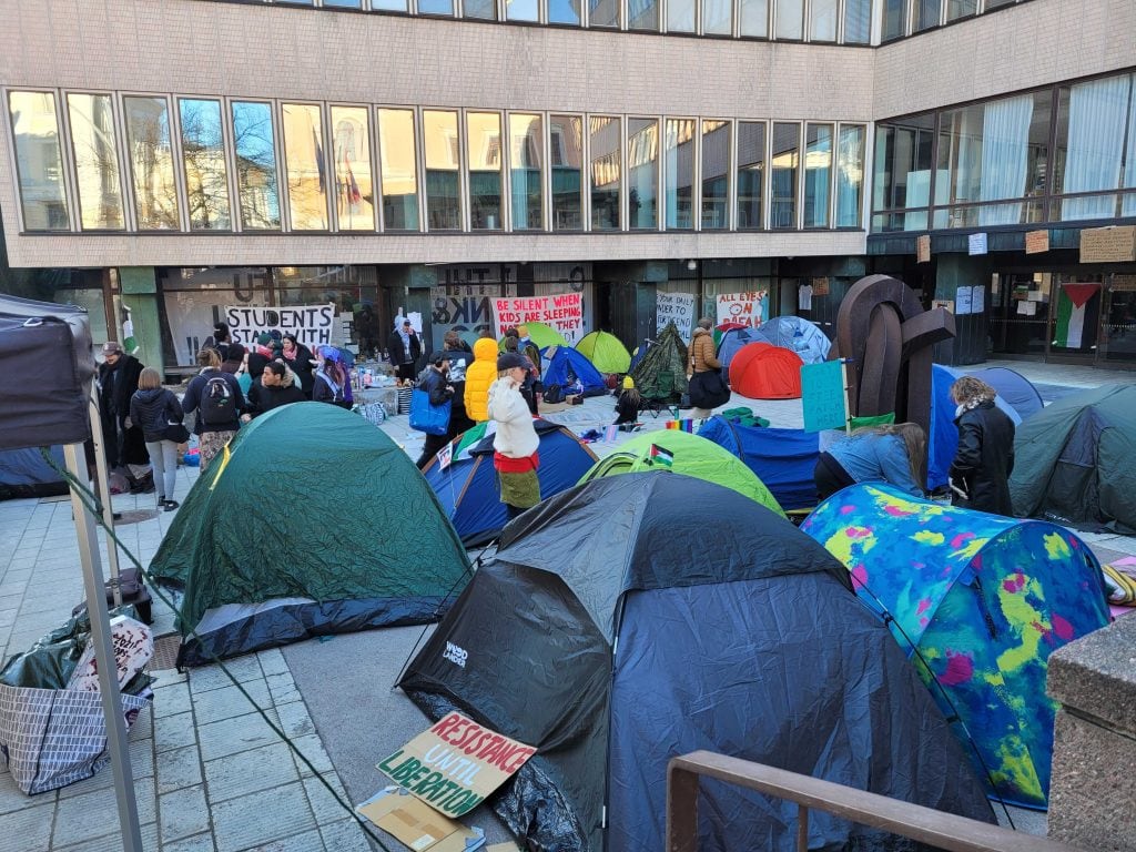 Porthania building's courtyard which is filled with colourful tents and hand written signs.